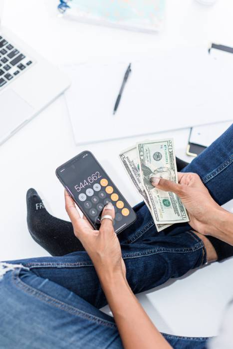 Woman budgeting with a calculator to prepare for real estate investing and financial stability